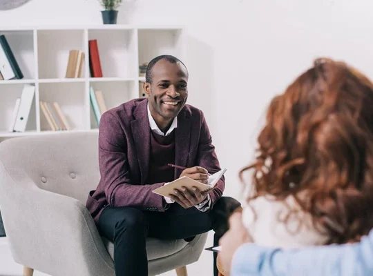 Smiling african american psychiatrist talking to young couple